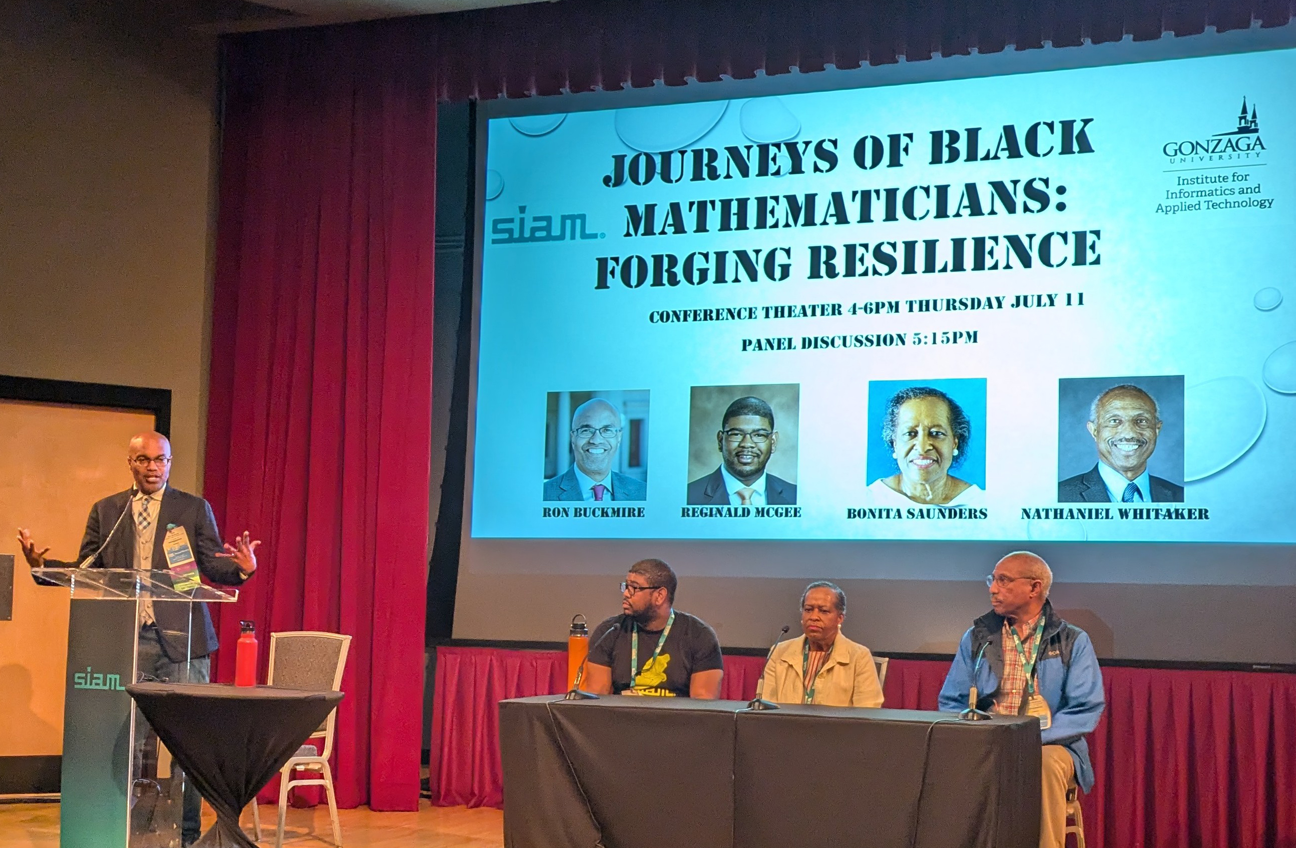 During the 2024 SIAM Annual Meeting, which took place in Spokane, Wash., this July, the Workshop Celebrating Diversity hosted a screening and discussion of a 2024 documentary titled &lt;em&gt;Journeys of Black Mathematicians: Forging Resilience&lt;/em&gt;. From left to right: moderator Ron Buckmire (Marist College) and panelists Reginald McGee (Haverford College), Bonita Saunders (National Institute of Standards and Technology), and Nathaniel Whitaker (University of Massachusetts Amherst). SIAM photo.