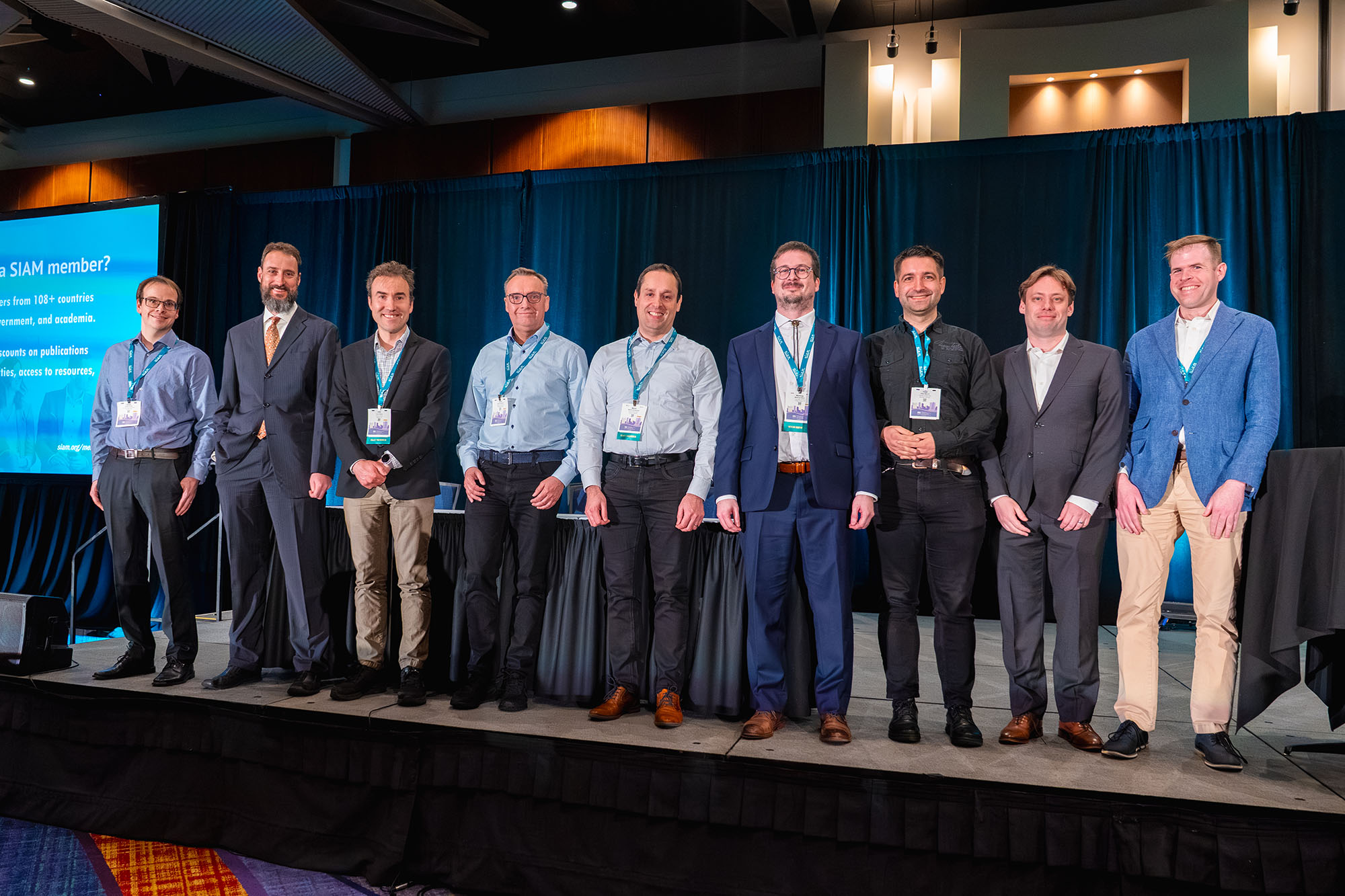 At the 2025 SIAM Conference on Computational Science and Engineering, which took place in Fort Worth, Texas, this past March, the principal authors of the deal.II project received the 2025 SIAM/ACM Prize in Computational Science and Engineering for their creation of a highly impactful library that supports finite element calculations. From left to right: Daniel Arndt of Oak Ridge National Laboratory, Wolfgang Bangerth of Colorado State University, Timo Heister of Clemson University, Guido Kanschat of Heidelberg University in Germany, Martin Kronbichler of Ruhr-Universität Bochum in Germany, Matthias Maier of Texas A&M University, Peter Munch of the Technical University of Berlin, Bruno Turcksin of Oak Ridge National Laboratory, and David Wells of the University of North Carolina at Chapel Hill. Not pictured are Bruno Blais of Polytechnique Montréal in Canada, Marc Fehling of Charles University in the Czech Republic, Rene Gassmoeller of the GEOMAR Helmholtz Centre for Ocean Research Kiel in Germany, Luca Heltai of the University of Pisa in Italy, and consultant Jean-Paul Pelteret. SIAM photo.