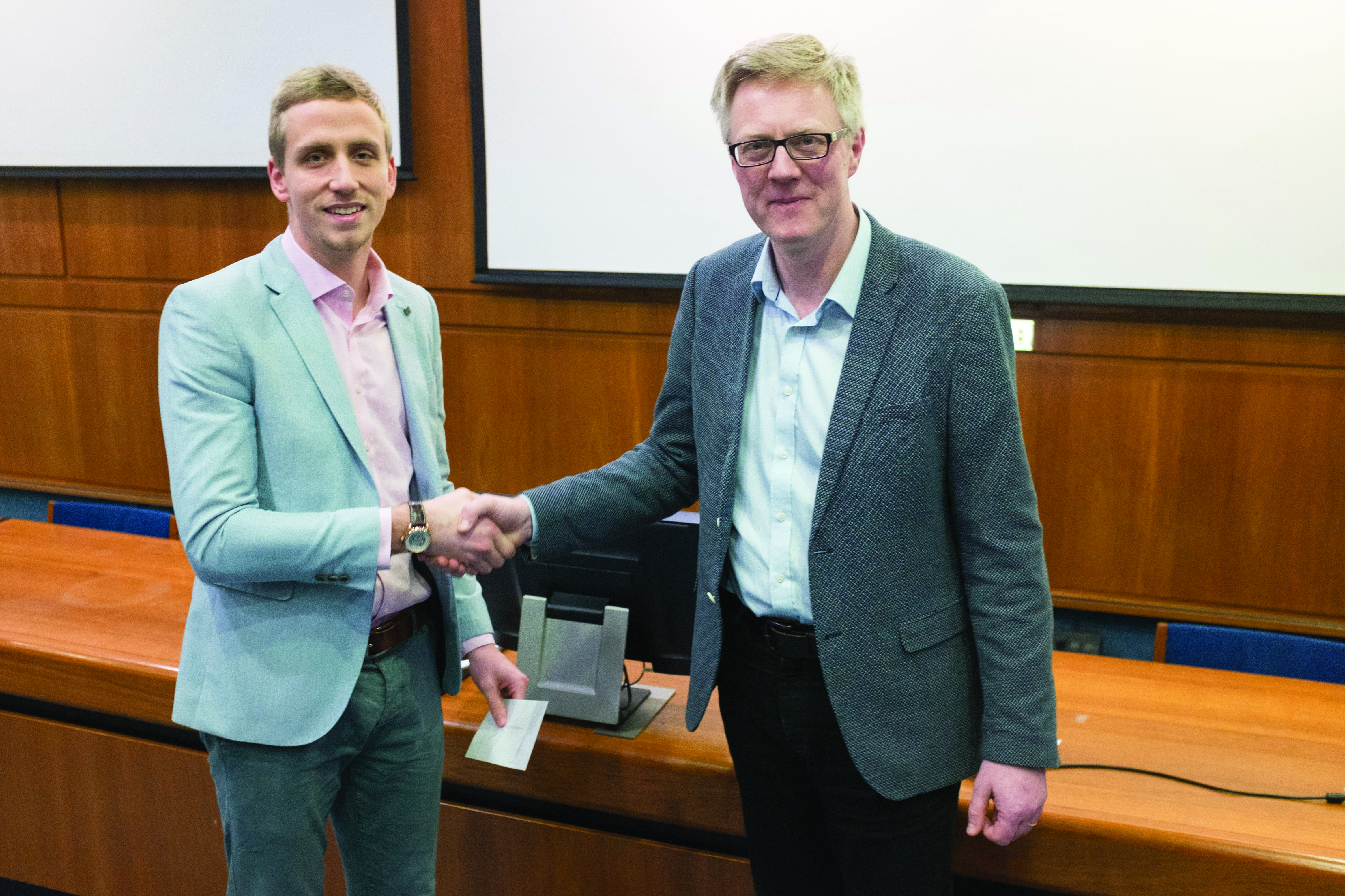 Scott Bagwell of Swansea University (left) won first prize in the student poster competition at the Annual Meeting of the UK and Republic of Ireland Section of SIAM, held January 12, 2017 at the University of Strathclyde. Professor Des Higham, president of the SIAM UKIE Section, presents Bagwell with his prize. The poster can be viewed online at http://maths.manchester.ac.uk/siam-ukie/annual2017. Image credit: Nicholas Higham.