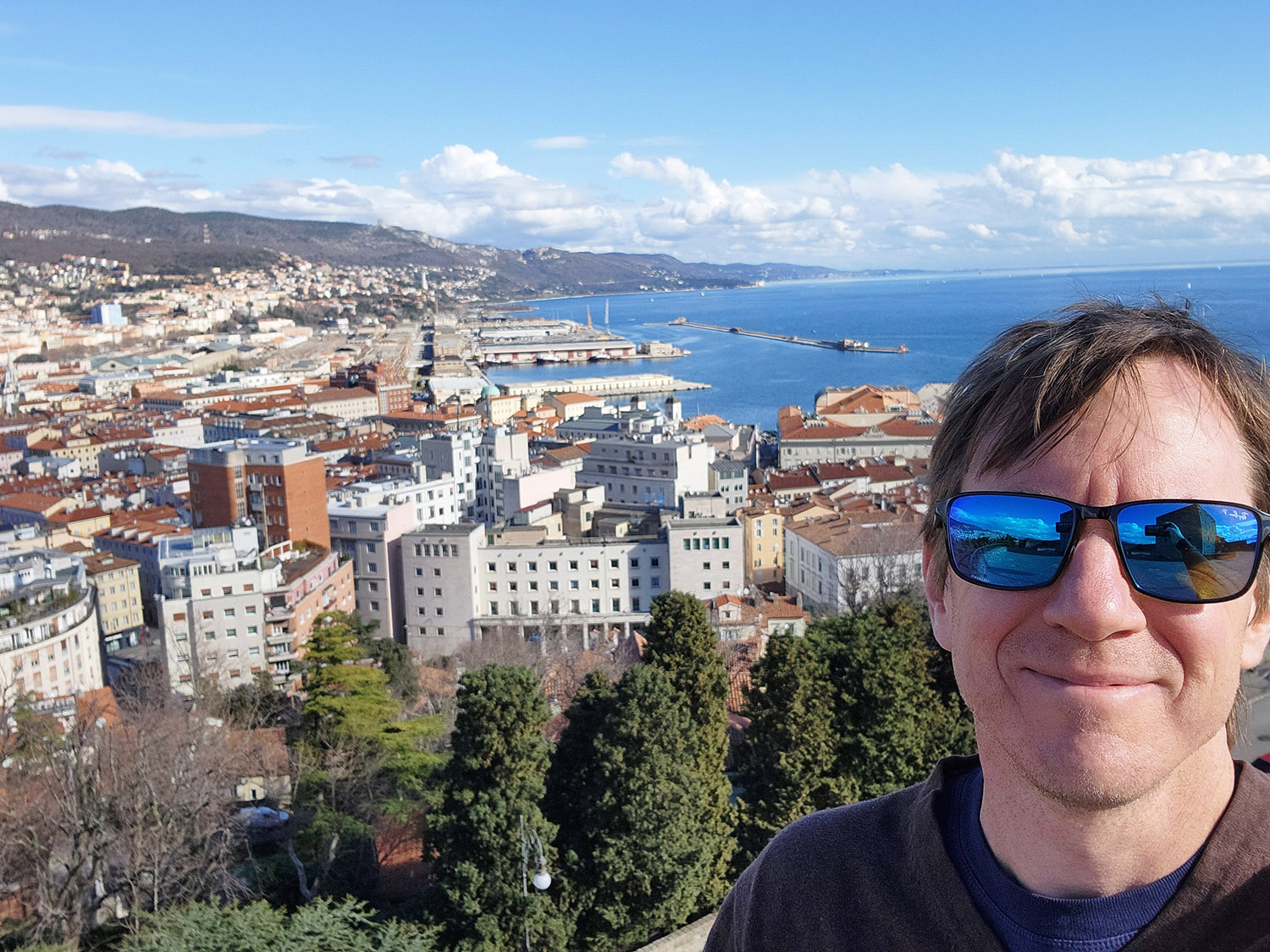 Richard Moore, SIAM’s Director of Programs and Services, enjoys the view from Castello di San Giusto in Trieste, Italy. Stazione Marittima—a converted maritime station at which the 2024 SIAM Conference on Uncertainty Quantification took place in February—is visible in the background. Photo courtesy of Richard Moore.