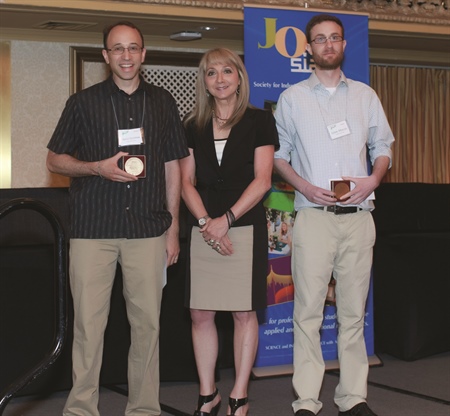 Daniel Spielman (left) and Adam Marcus accepted the George Pólya Prize from SIAM president Irene Fonseca at the Annual Meeting in Chicago.