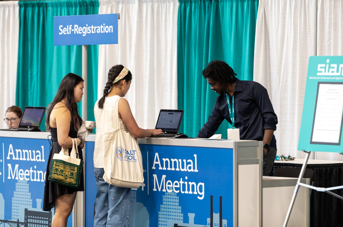 Attendees of the 2024 SIAM Annual Meeting, which took place in Spokane, Wash., last July, visit the registration desk. All SIAM conference attendees now have the option to bundle the purchase of SIAM membership with conference registration. SIAM photo.