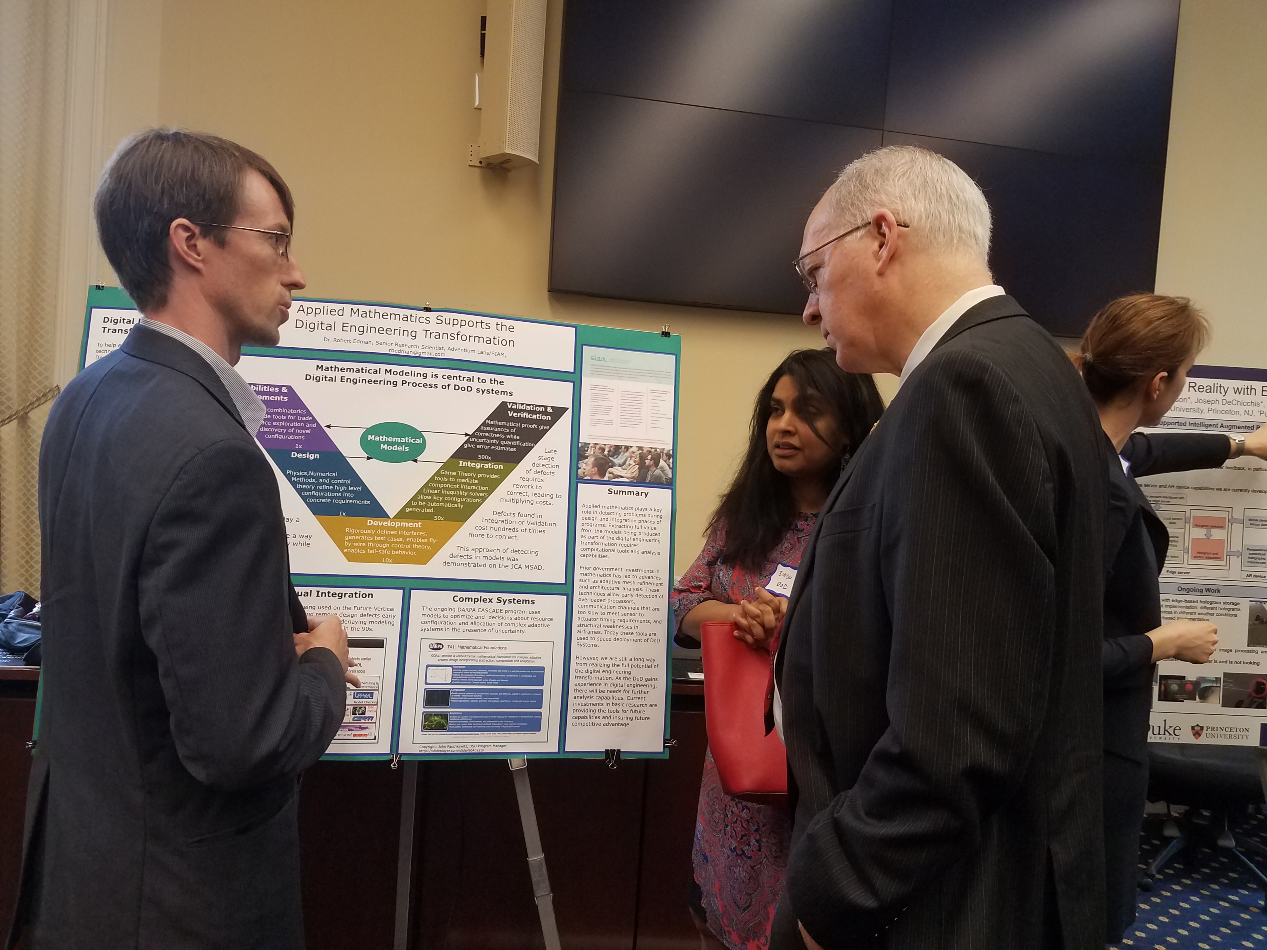SIAM Science Policy Fellowship recipient Robert Edman (Adventium Labs) presents a poster illustrating the importance of applied mathematics to the Department of Defense mission at the second annual Science, Technology, & Innovation Exchange briefing, which took place in May on Capitol Hill in Washington, D.C. Here he converses with Bindu Nair (Office of the Secretary of Defense) and Representative Bill Foster (D-IL). Photo courtesy of Eliana Perlmutter.