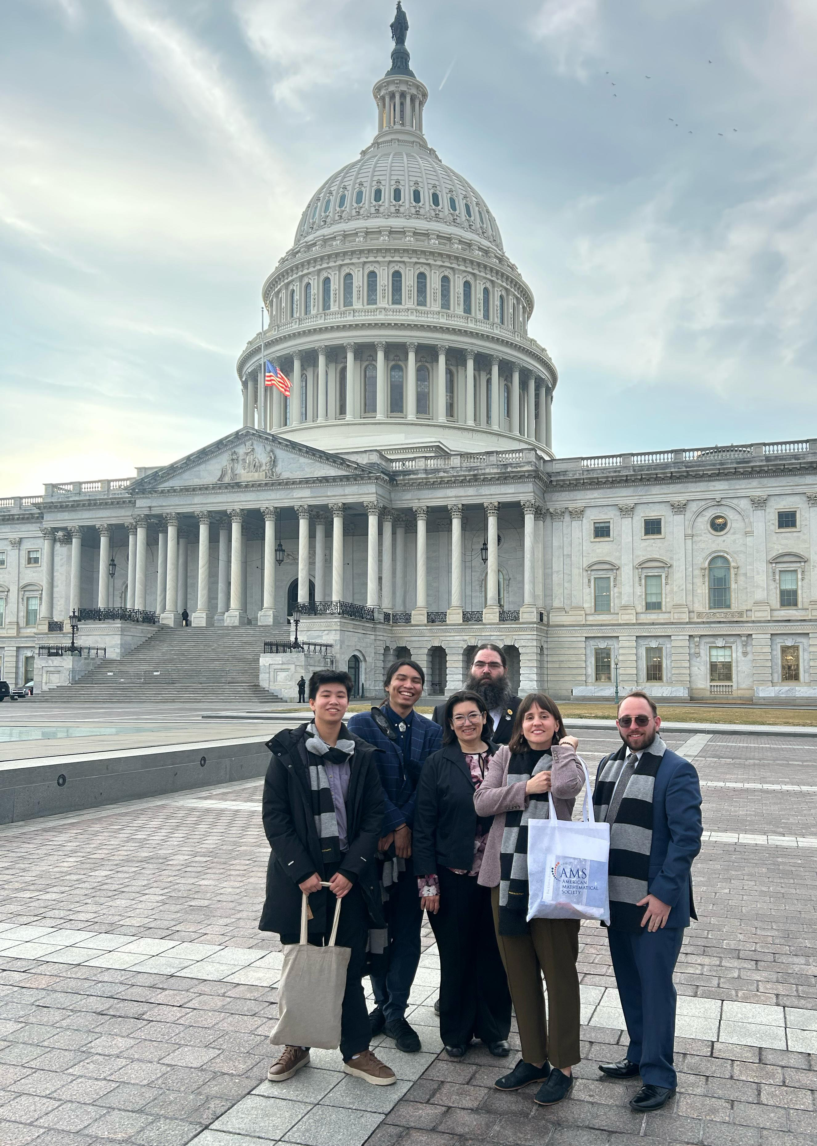 At the #MathSciOnTheHill advocacy event, which took place on January 8 in Washington, D.C., members of the New Mexico delegation gather in front of the U.S. Capitol after watching the U.S. House of Representatives pass legislation that funded mathematics and science research. From left to right: Isa Chou (Williams College), Tommy Denny-Martins (Purdue University), Anita Chou (CAMP for Algorithmic and Mathematical Play), Nick Allgood (U.S. Air Force Research Laboratory), Anna Nelson (University of New Mexico), and Jonas Actor (Sandia National Laboratories). Photo courtesy of Anna Nelson.
