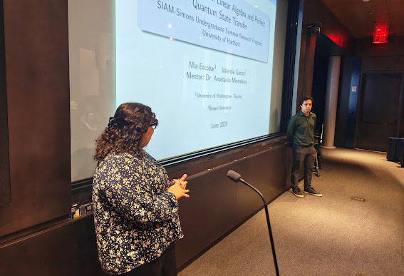 Mia Escobar of the University of Washington Tacoma (left) and Valentin Garcia of Brown University present their research at the Simons Foundation’s Flatiron Institute in New York City. Student participants of the 2025 SIAM-Simons Undergraduate Summer Research Program visited the Flatiron Institute to meet one another, share their projects, and tour the facility. Photo courtesy of the author.